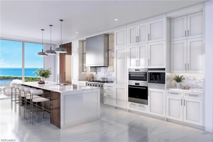 Kitchen with decorative backsplash, double oven, an island with sink, light stone countertops, and a water view