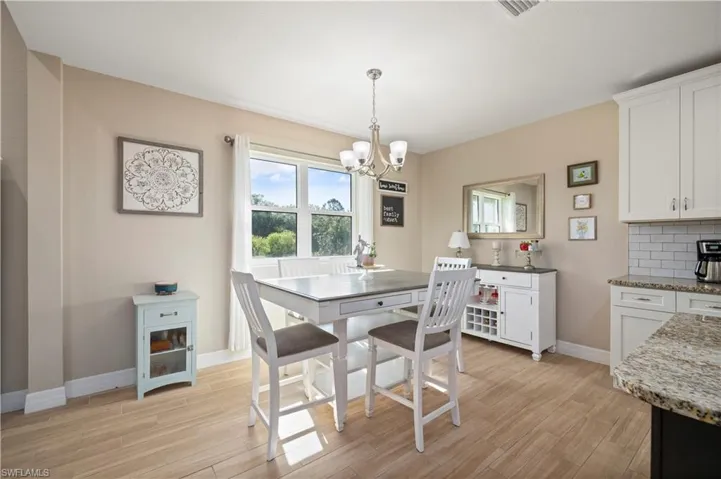 Dining area featuring a chandelier, light wood-style flooring, baseboards, and visible vents