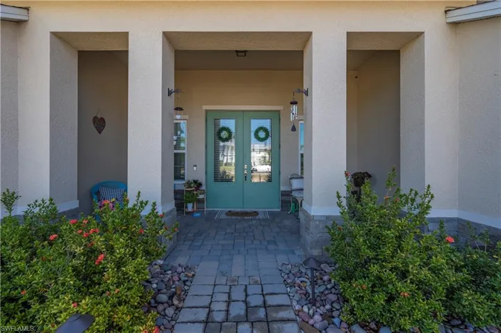 View of exterior entry featuring stucco siding and french doors