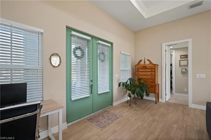 Foyer entrance with french doors, baseboards, light wood finished floors, visible vents, and crown molding