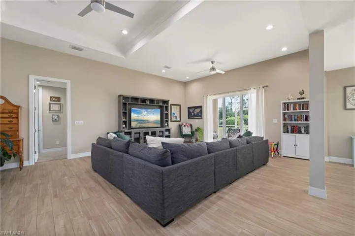Living area with ceiling fan, light wood-style flooring, baseboards, and visible vents