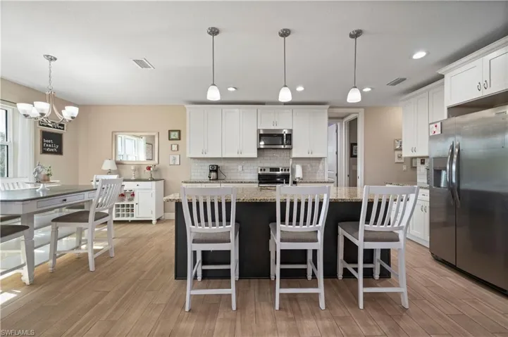 Kitchen featuring light wood-type flooring, visible vents, tasteful backsplash, and appliances with stainless steel finishes