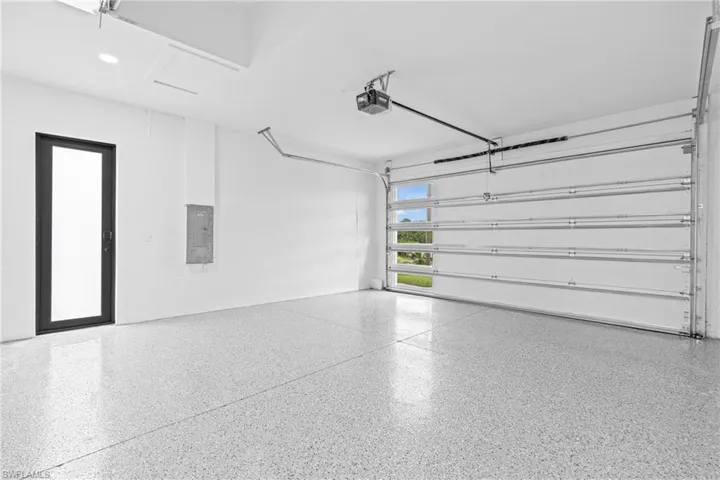 Garage featuring electric panel and a garage door opener