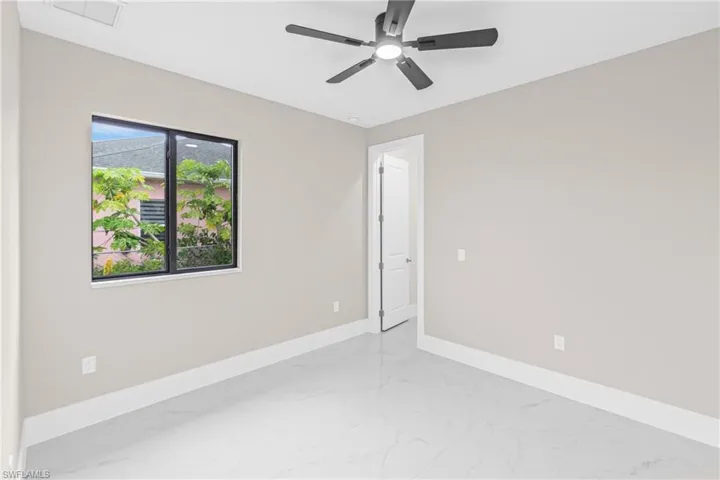 Spare room with light marble finish flooring and ceiling fan