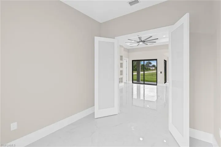 Unfurnished room featuring light marble finish floors, recessed lighting, and french doors