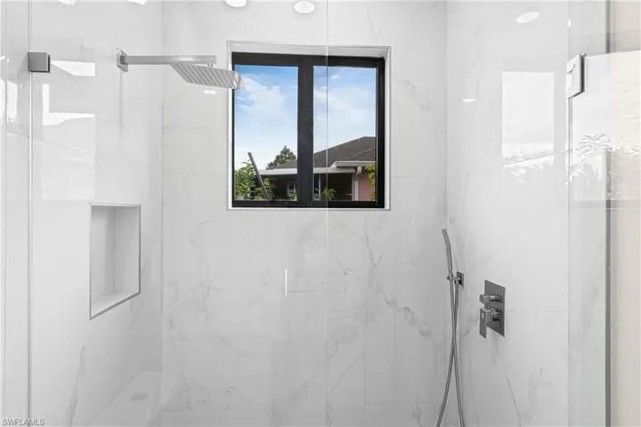 Full bath with a marble finish shower