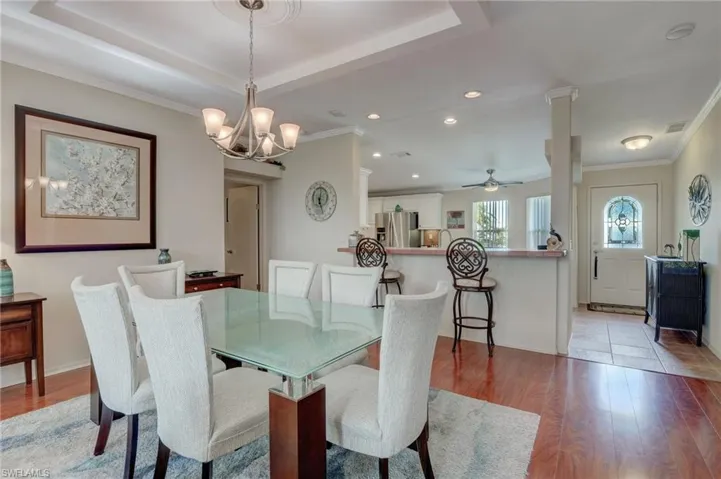Dining space featuring crown molding, ceiling fan with notable chandelier, and light hardwood / wood-style flooring