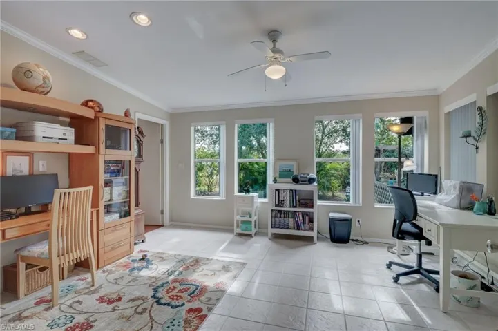 Tiled Den featuring ceiling fan, a healthy amount of sunlight, and crown molding