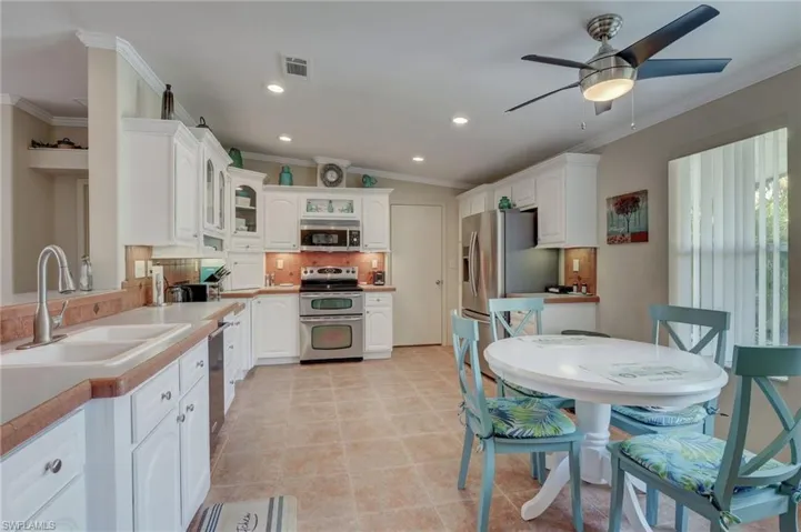 Kitchen featuring white cabinets, appliances with stainless steel finishes, and sink