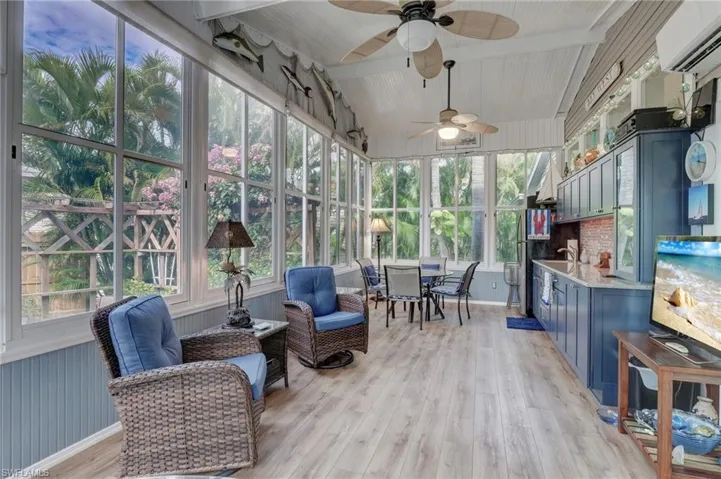 Sunroom / solarium featuring ceiling fan, vaulted ceiling with beams, a wealth of natural light, and a wall unit AC