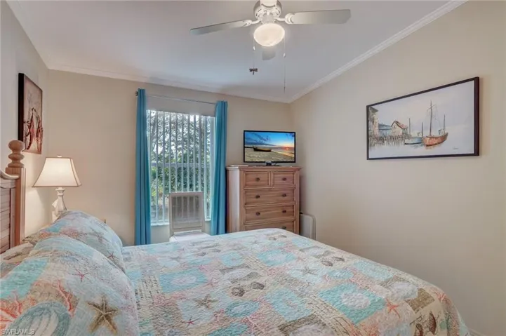 Bedroom with ceiling fan and ornamental molding