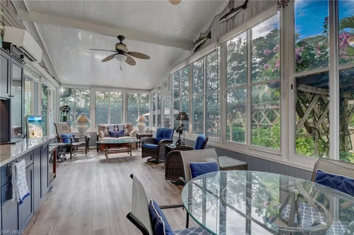 Sunroom / solarium featuring ceiling fan, a wall unit AC, and vaulted ceiling
