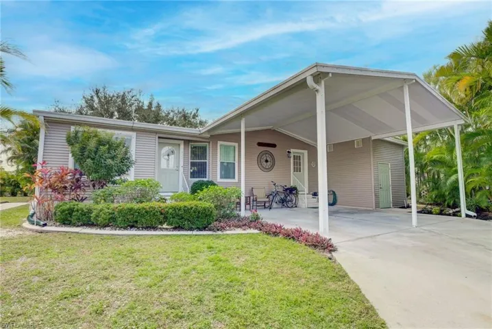 View of front of home featuring a front lawn and a carport
