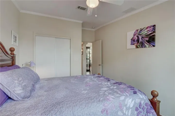 Bedroom with ceiling fan, crown molding, and a closet