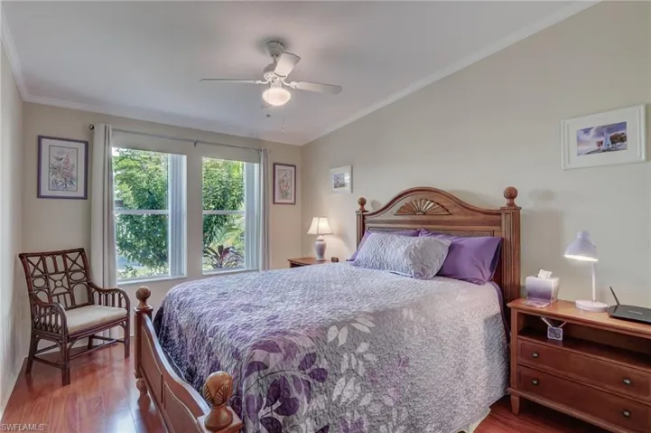 Bedroom with ceiling fan, crown molding, and hardwood / wood-style floors
