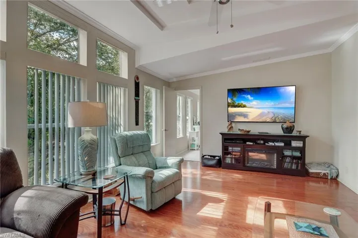 Living room featuring ceiling fan, crown molding, and hardwood / wood-style floors