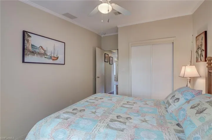 Bedroom featuring ceiling fan, a closet, and ornamental molding