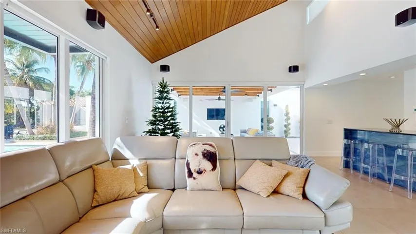 Living room with high vaulted ceiling and wooden ceiling