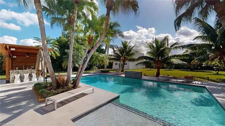 View of swimming pool with a patio and exterior bar