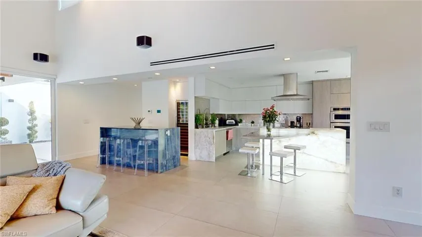 Living room featuring a high ceiling and light tile patterned flooring