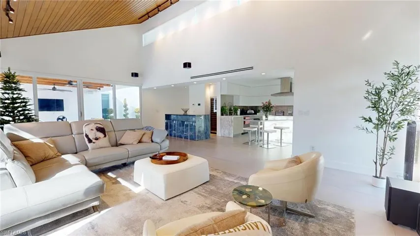 Tiled living room featuring high vaulted ceiling, wooden ceiling, and ceiling fan