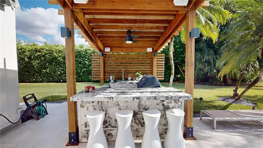 View of patio with ceiling fan and an outdoor bar