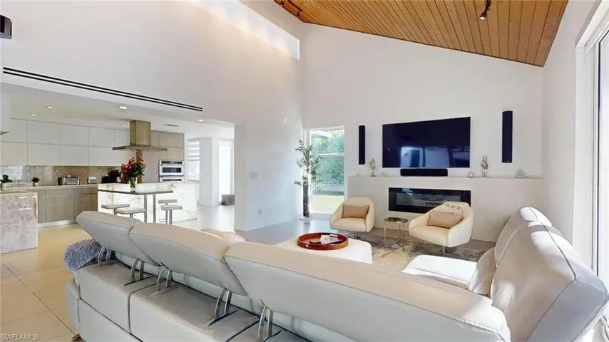 Tiled living room with high vaulted ceiling and wooden ceiling