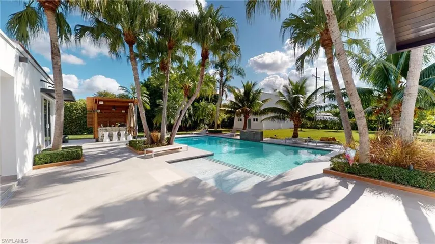 View of pool featuring an outdoor bar and a patio area