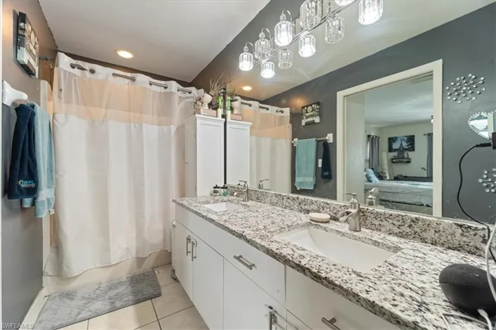 Bathroom featuring a double vanity with stone countertops, integrated sinks, and brushed nickel faucets