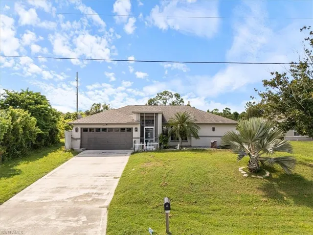 Ranch-style exterior with a screened entry, attached two-car garage, and concrete driveway