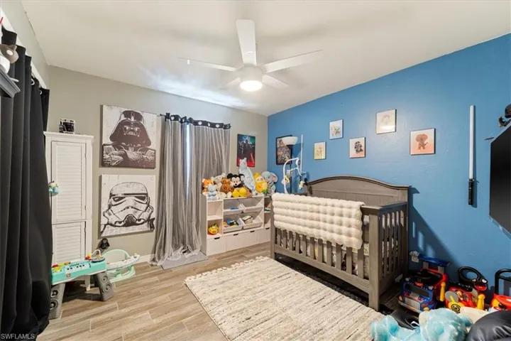 Room featuring wood-look tile flooring and a ceiling fan