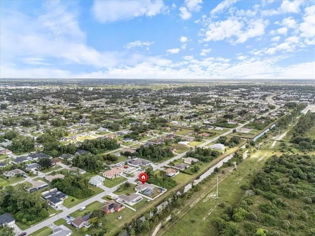 Aerial perspective showcasing a developed residential area with numerous single-story homes, surrounded by abundant green landscaping and mature trees