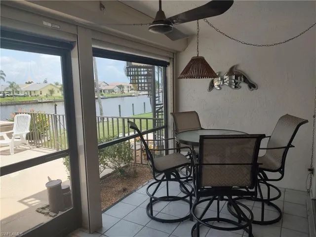 Sunroom featuring a water view and ceiling fan