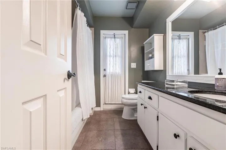 Full bathroom with vanity, baseboards, toilet, and a shower with curtain