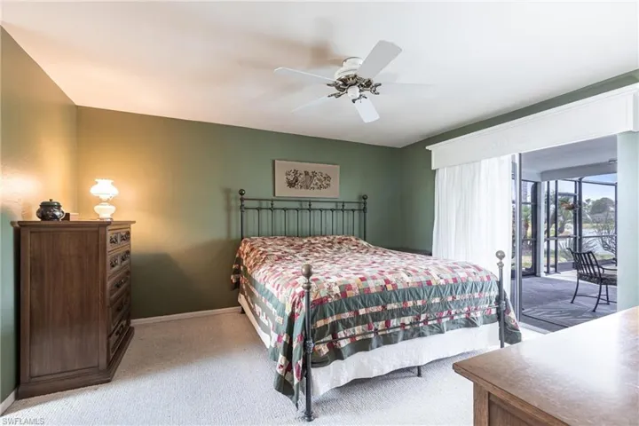 Bedroom with baseboards, light carpet, a ceiling fan, and access to exterior