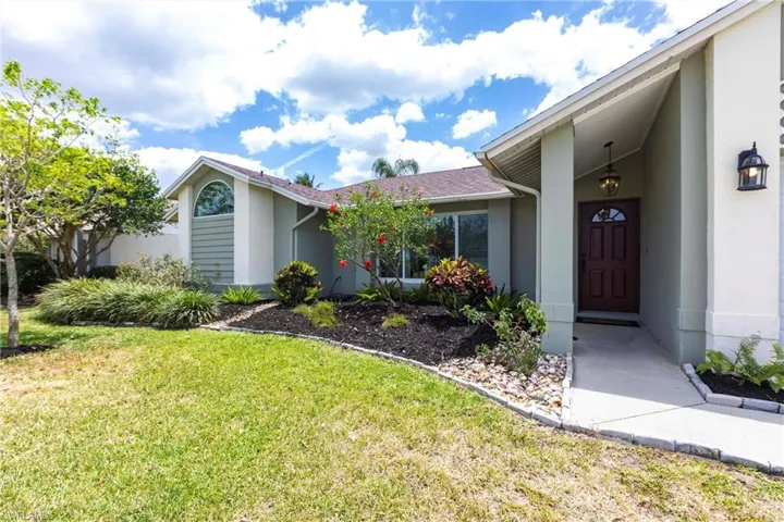 View of front of house with a front yard and stucco siding