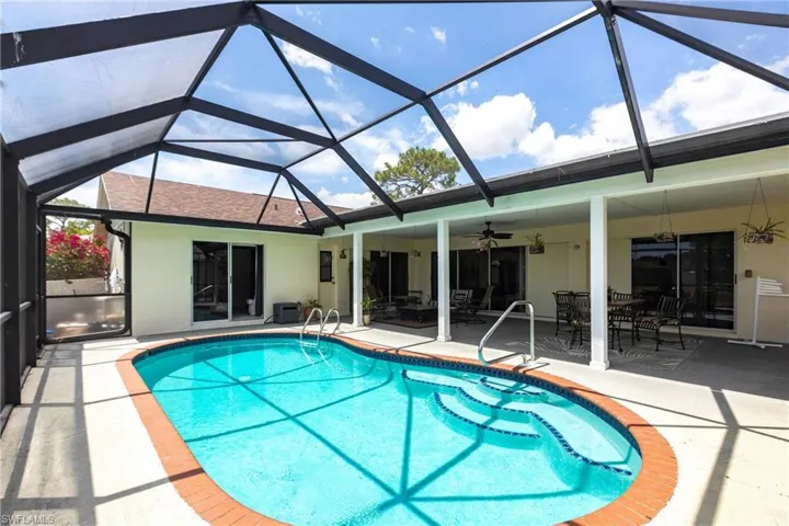 Pool featuring a lanai, a ceiling fan, a patio, and outdoor dining space