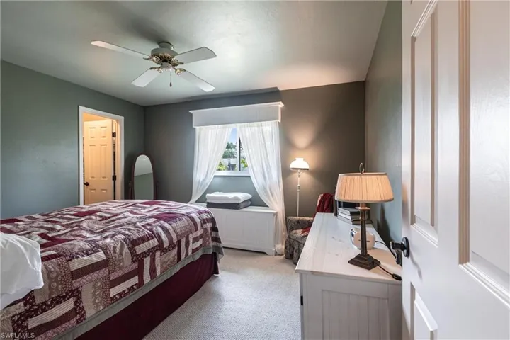 Bedroom with ceiling fan and light colored carpet