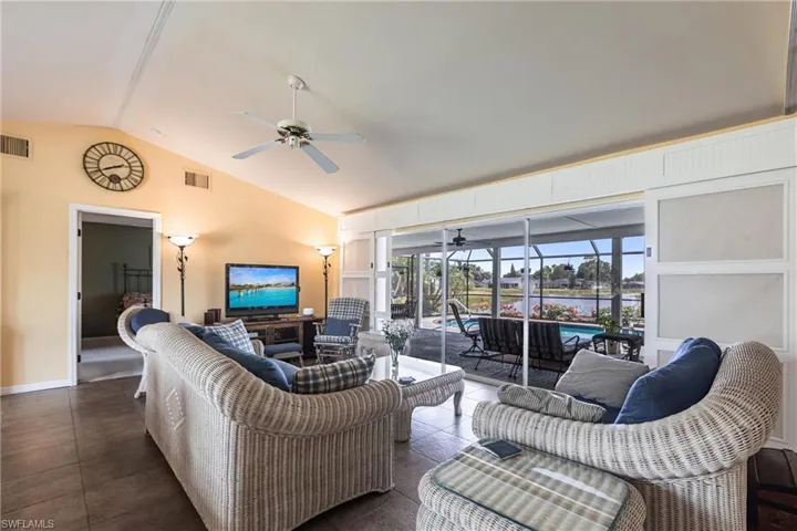 Living area featuring visible vents, ceiling fan, a sunroom, and lofted ceiling