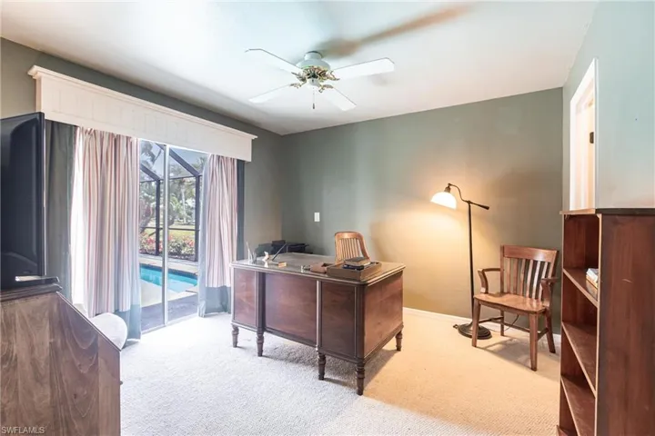 Office space with carpet flooring, ceiling fan, and baseboards