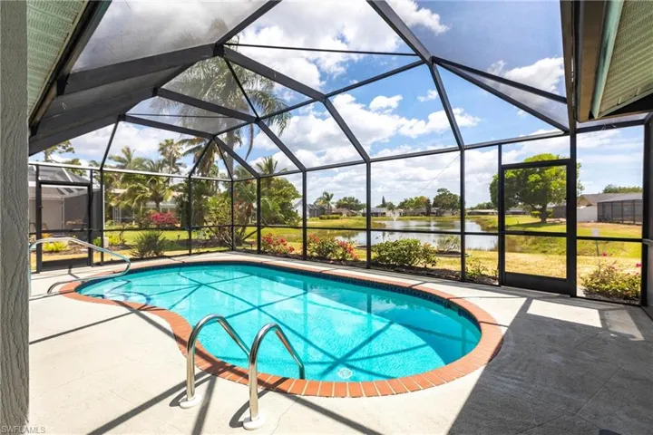 Pool featuring a patio, a water view, and glass enclosure