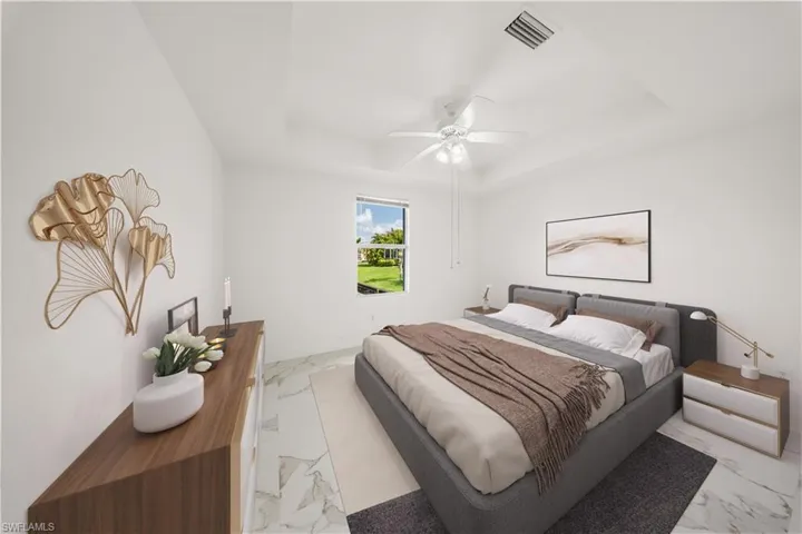 Bedroom featuring a raised ceiling, a ceiling fan, and light marble finish flooring