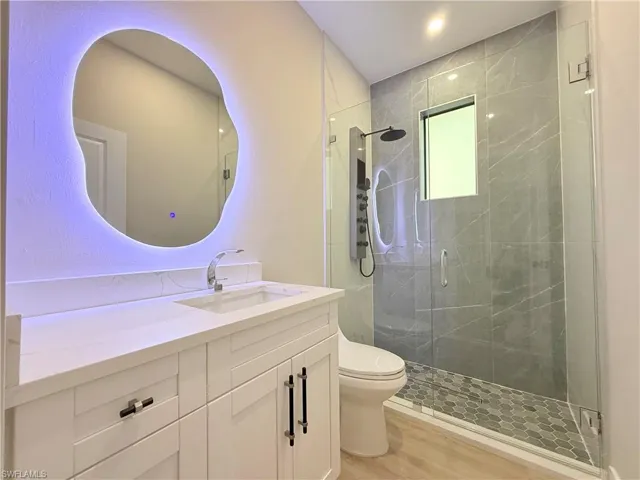 Bathroom featuring vanity, a shower stall, light wood-type flooring, and recessed lighting