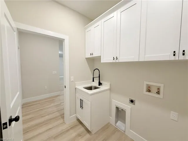 Laundry area featuring cabinet space, light wood-type flooring, hookup for a washing machine, and electric dryer hookup
