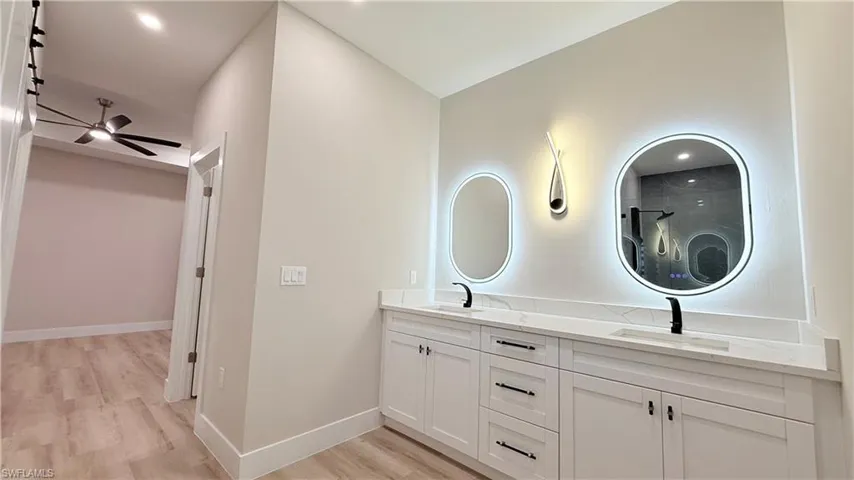 Master bathroom with double vanity and light wood-type flooring