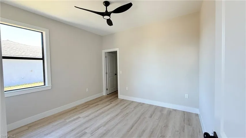 Empty room featuring light wood-type flooring and a ceiling fan