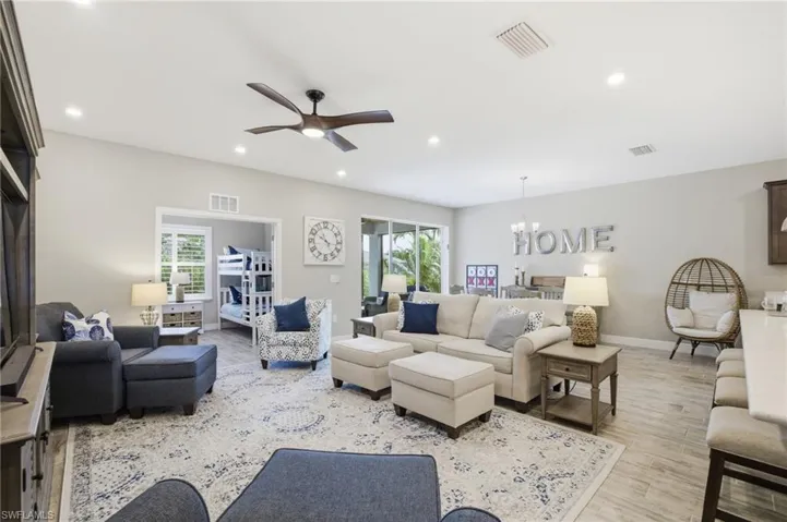 Bright living area featuring recessed lighting, a ceiling fan, and light-toned walls