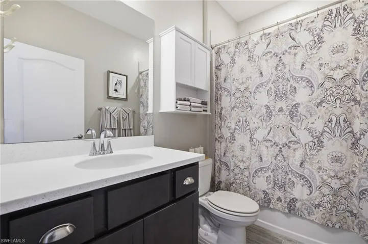 Bathroom featuring a dark wood-finish vanity with a white countertop and undermount sink