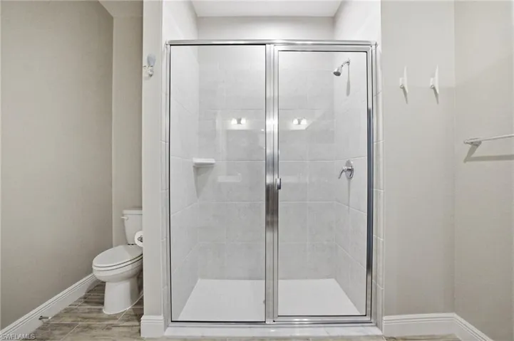 Walk-in shower with clear glass enclosure and brushed chrome fixtures