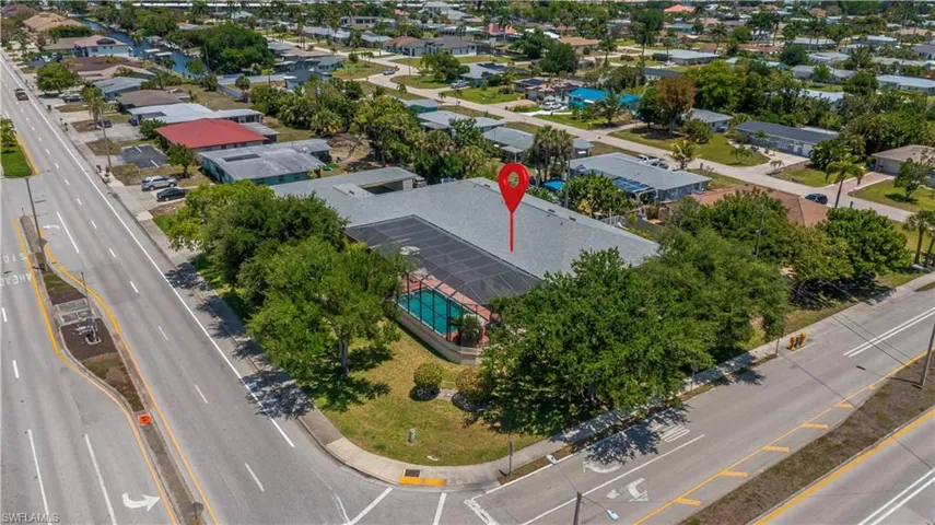 Corner lot property featuring a screened-in swimming pool